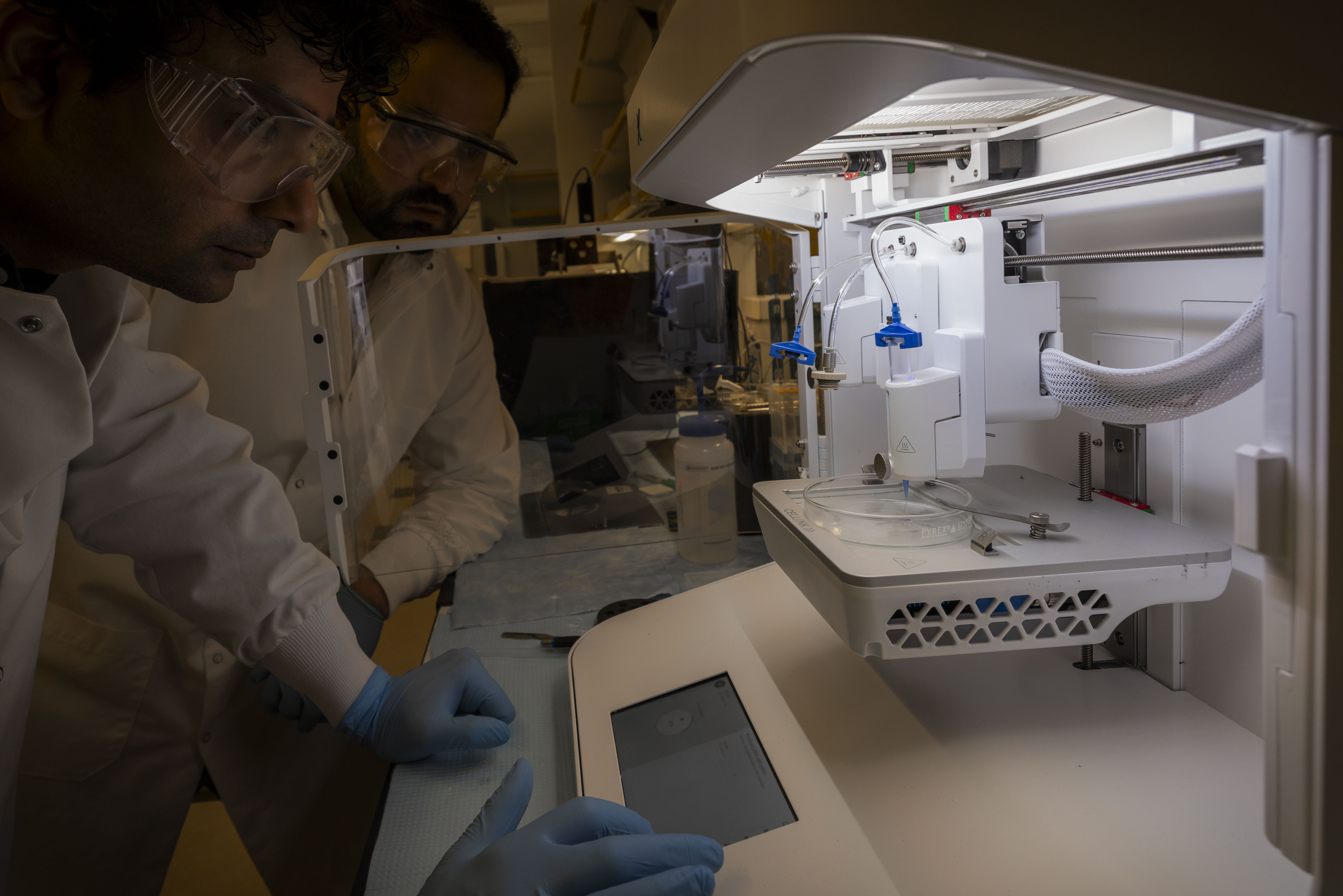 Dr. Indranath Mitra and Sulaiman Khan, a doctoral student in Applied Science, use a 3D bioprinter to create a scaffold. (Photo by Timothy Sofranko)