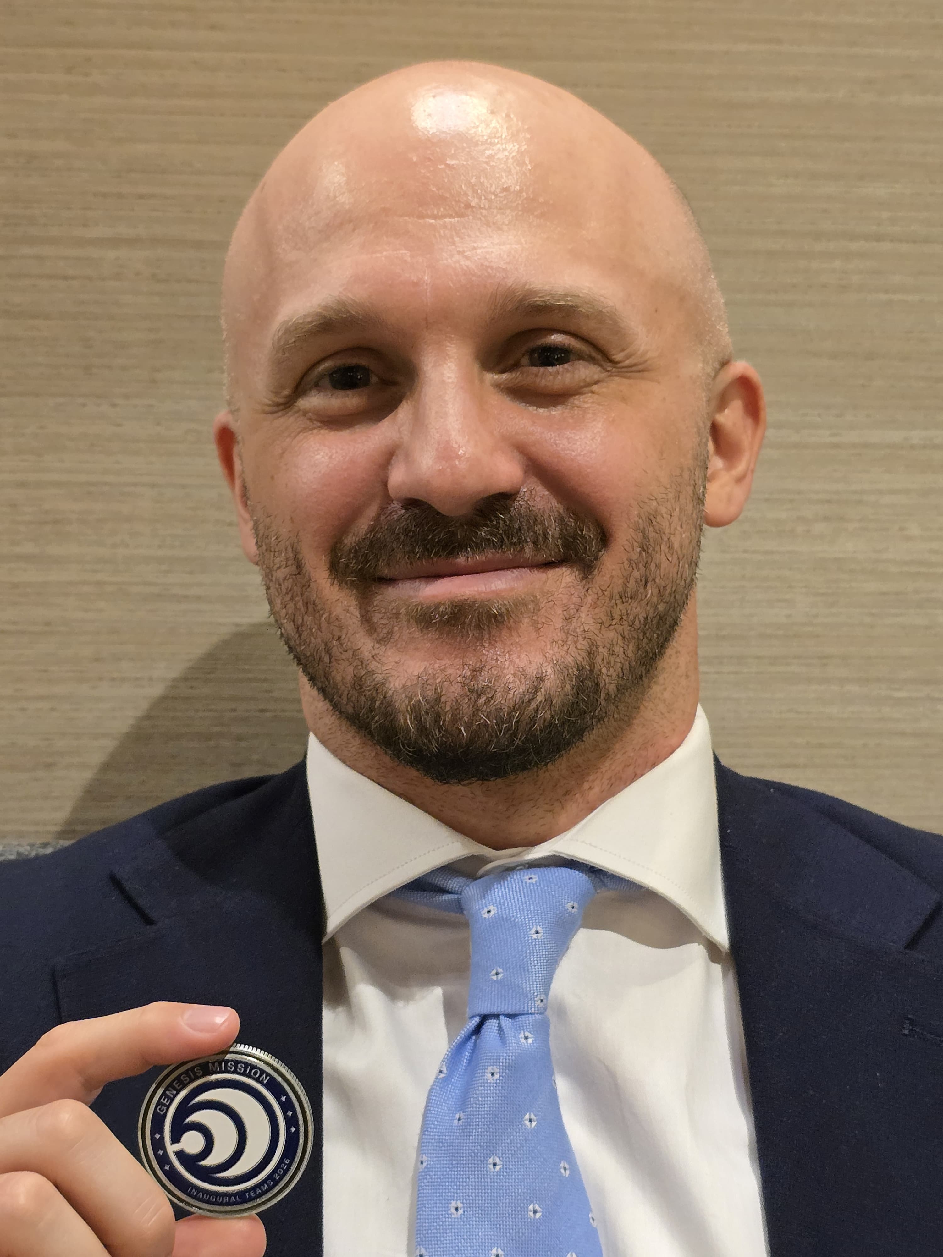 Dr. Cristiano Fanelli receives the Genesis Mission coin while attending the Genesis Mission Summit on July 22, 2026.