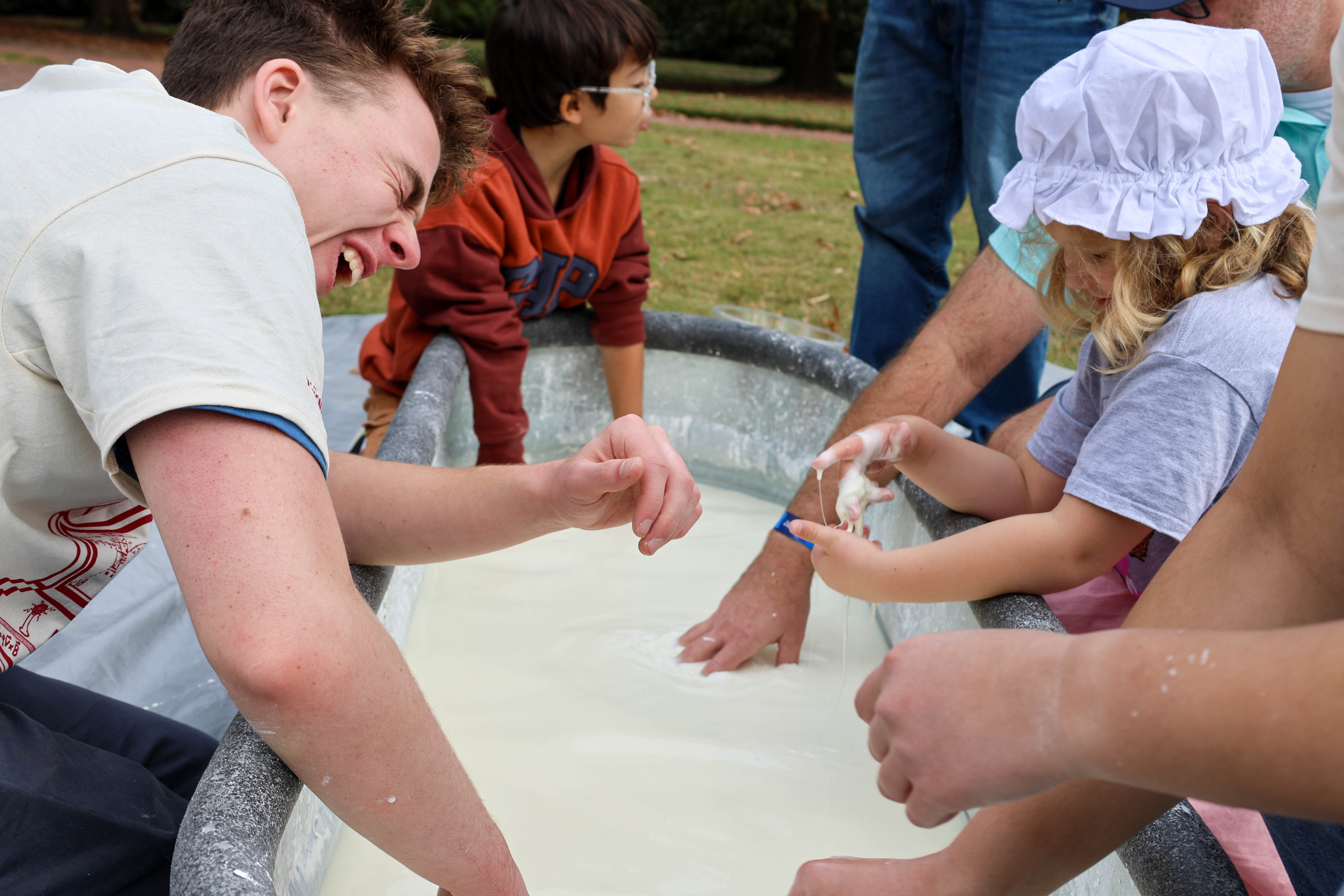 Kids stick their hands in the "Frogger" oobleck pool at PhysicsFest. Photo by Emmanuel Sampson