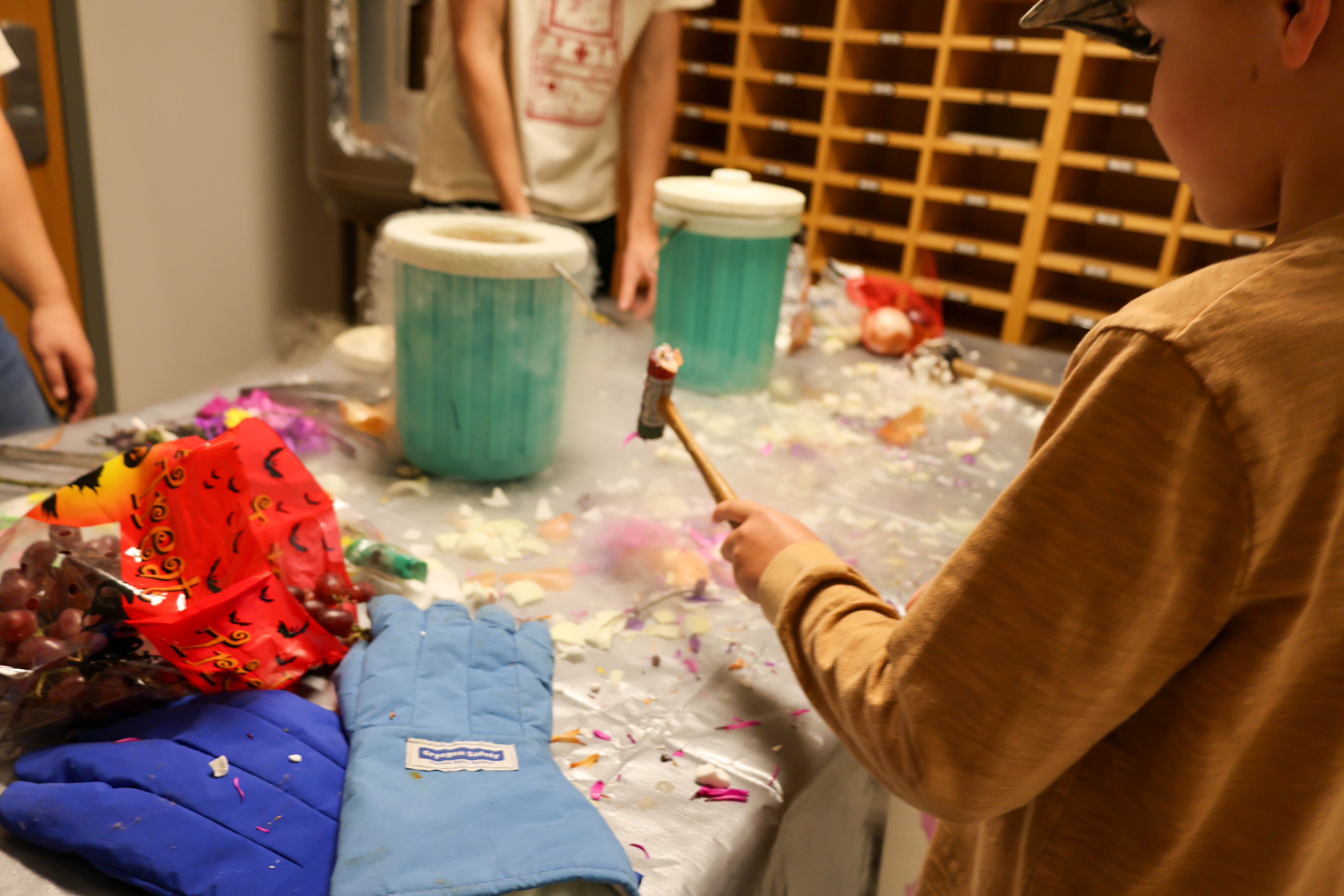 A child prepares to smash an object frozen with liquid nitrogen during PhysicsFest. Photo by Emmanuel Sampson